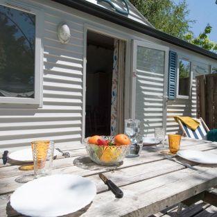 La terrasse est en bois et équipée d'une table