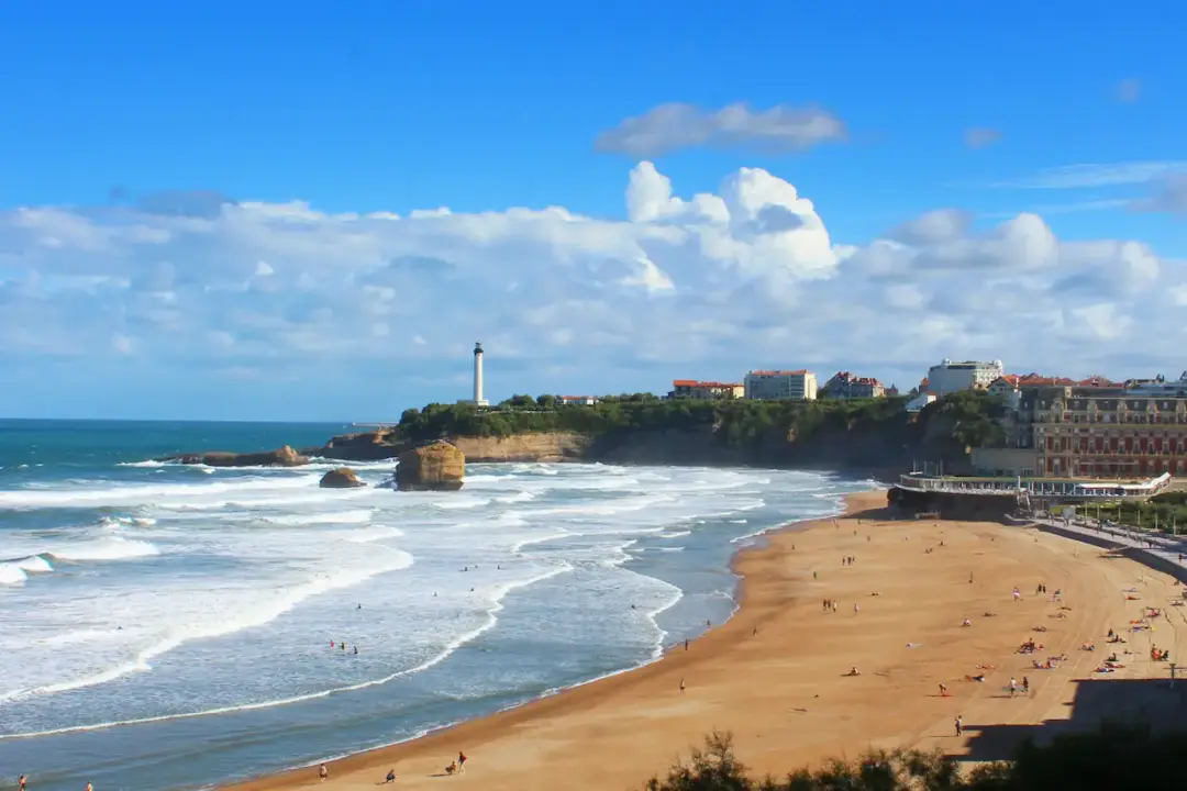 Plage avec phare sous ciel bleu à Biarritz.