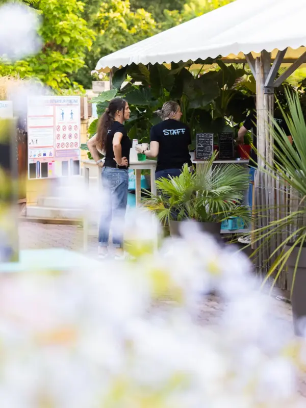 Personnel discutant sous un kiosque dans un jardin.