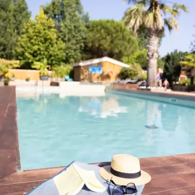 Piscine avec chapeau, lunettes et livre.