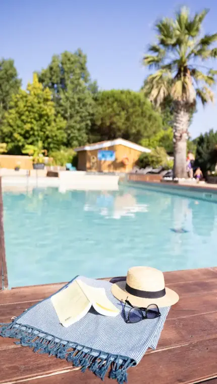 Piscine avec chapeau, lunettes et livre.