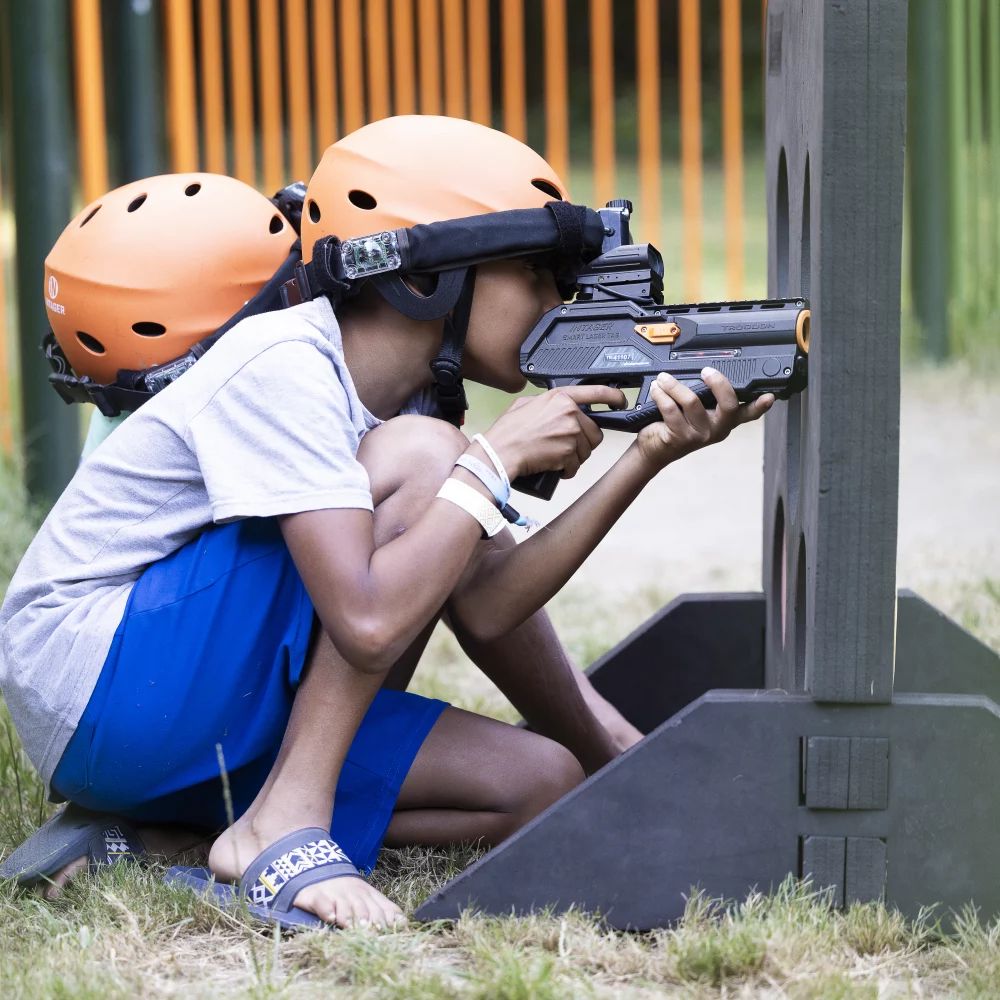 Enfant jouant au laser tag, casque orange.