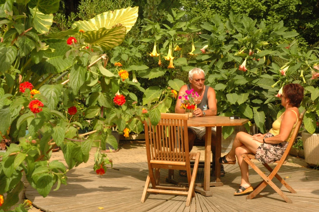 Deux personnes assises à une table dans un jardin.