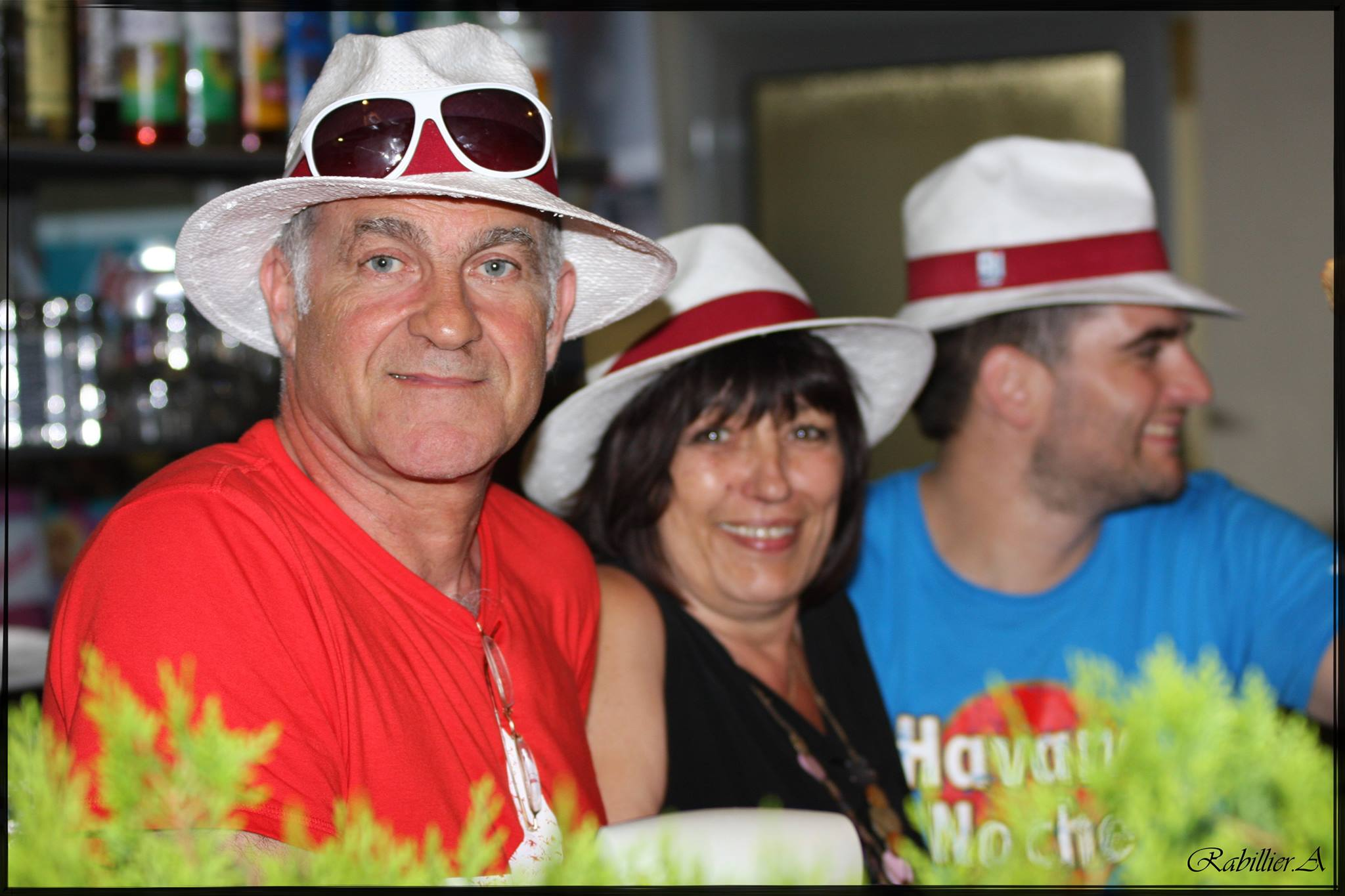 Trois personnes souriant avec des chapeaux blancs.