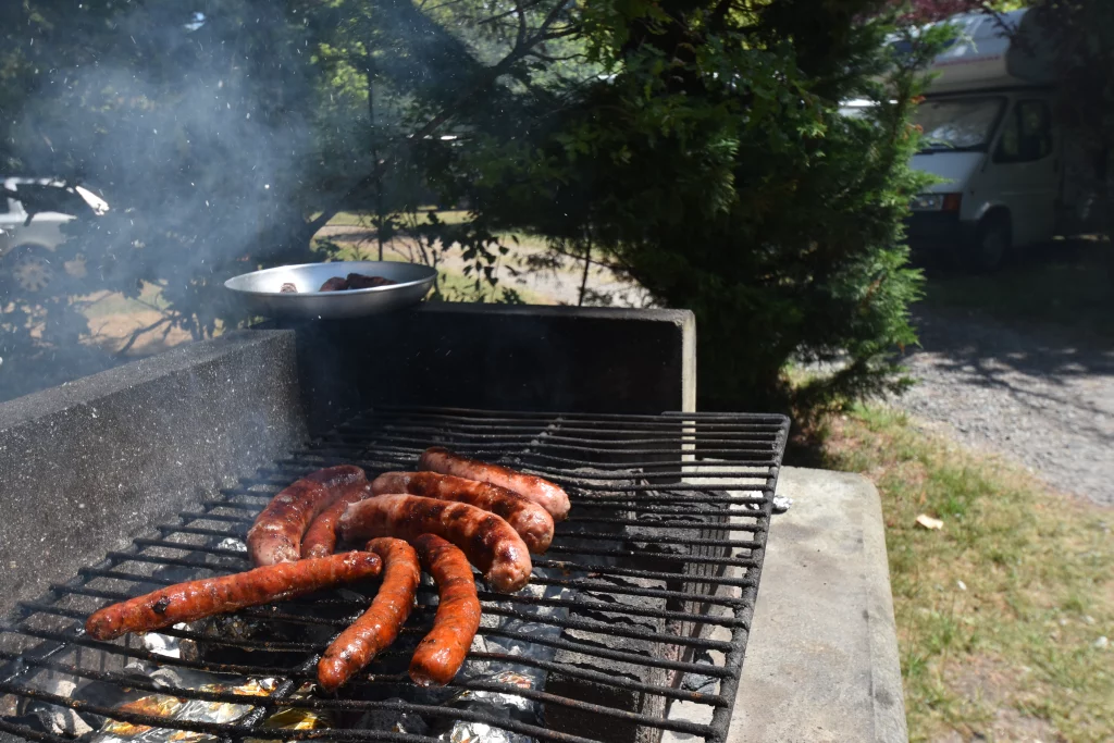 Saucisses grillées sur barbecue en plein air.