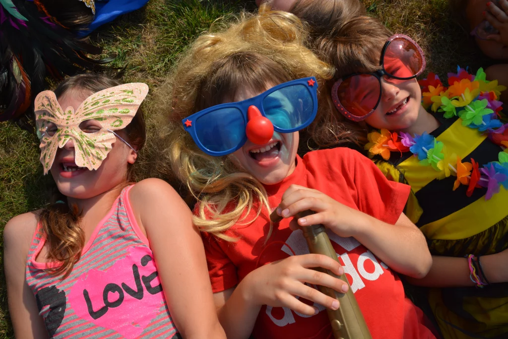 Enfants déguisés rient sur l'herbe.