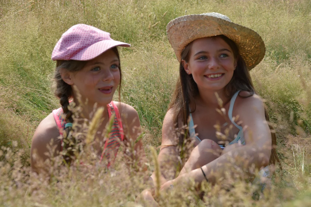 Deux filles souriantes dans un champ.