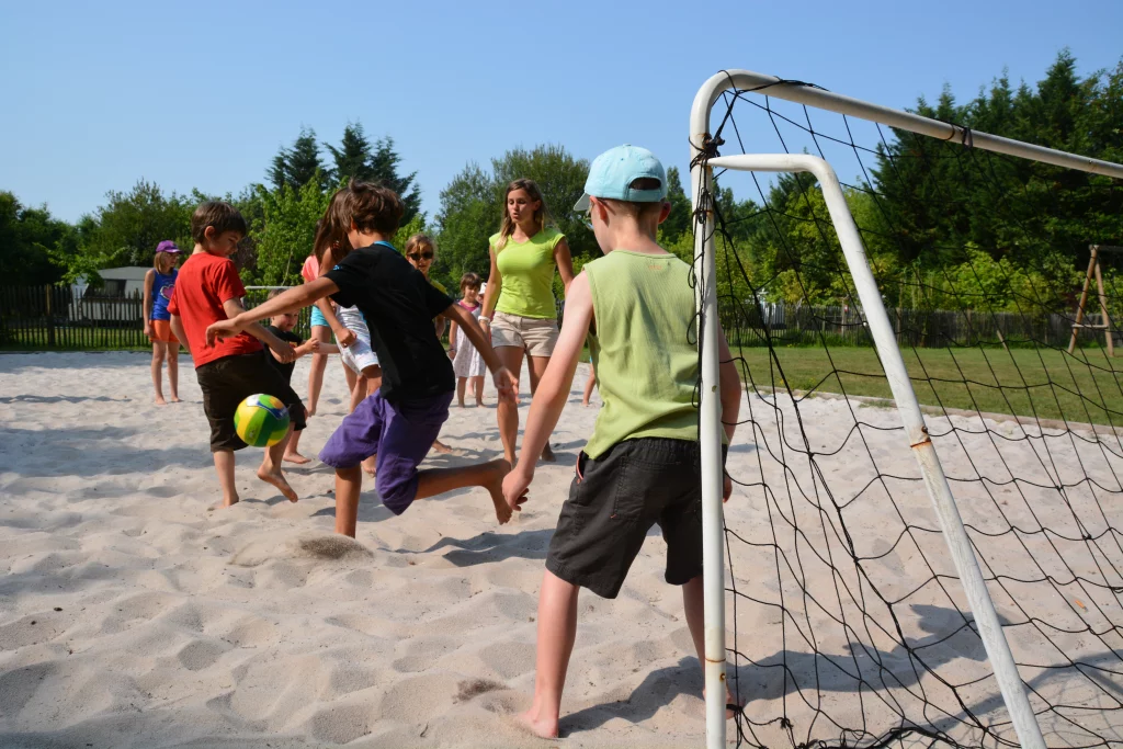 Enfants jouant au foot sur le sable