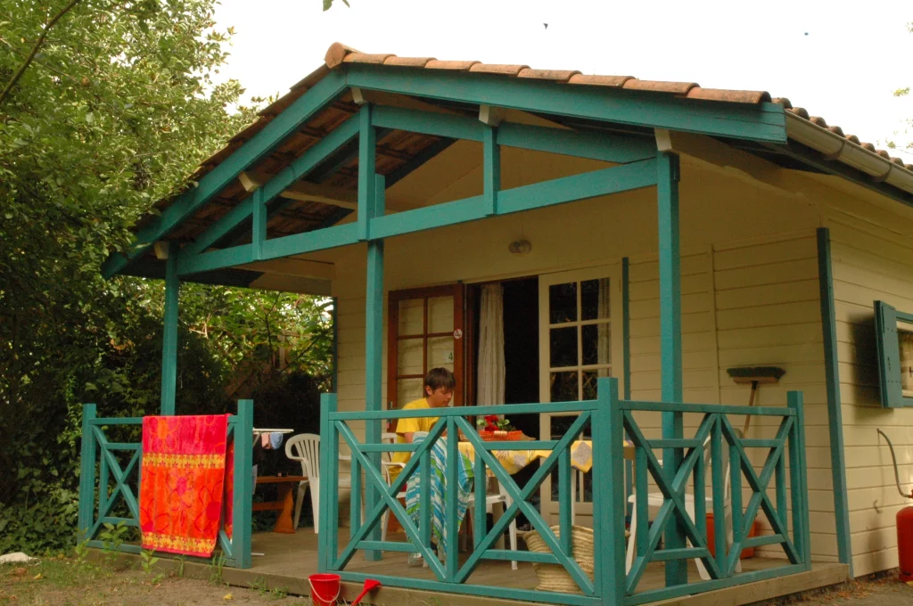 Chalet en bois avec terrasse et jardin.