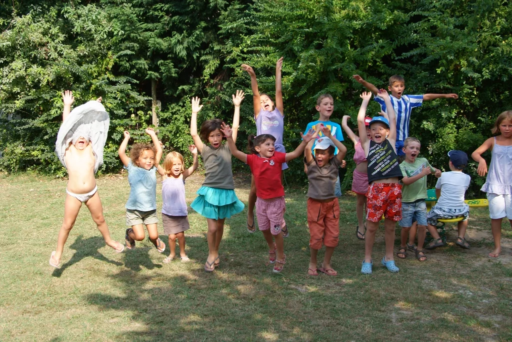 Enfants sautant joyeusement dans un parc verdoyant.