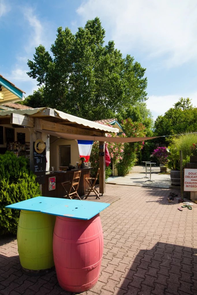 Terrasse de café extérieur avec terrasse et drapeau français.