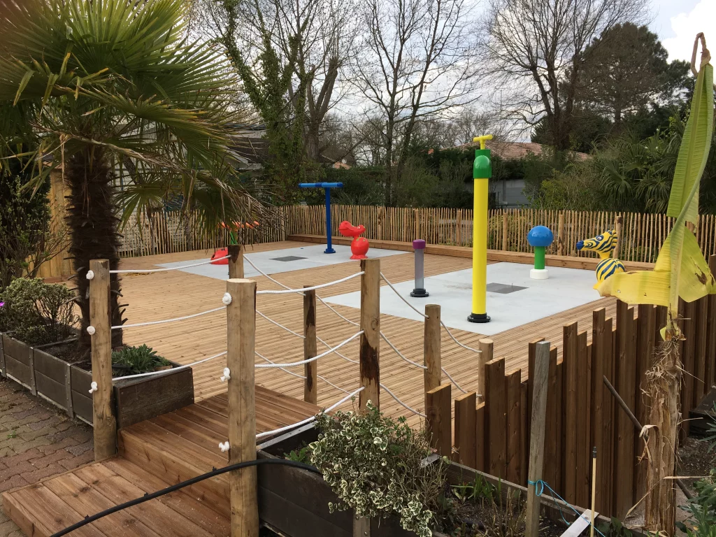Aire de jeu aquatique en bois avec jets colorés.