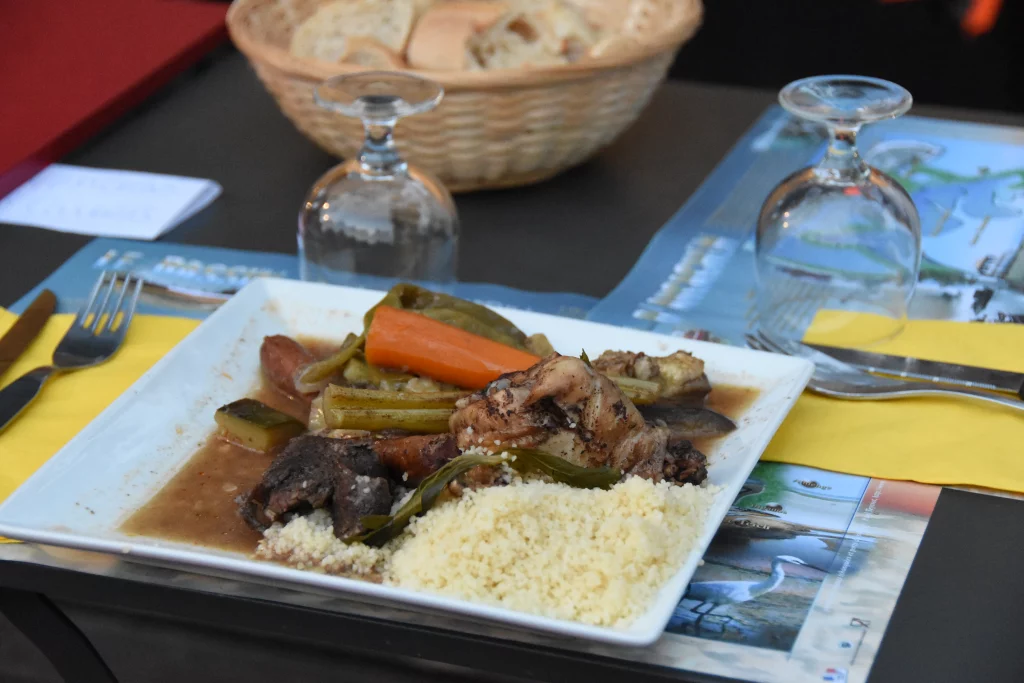 Assiette de couscous avec légumes et viande.