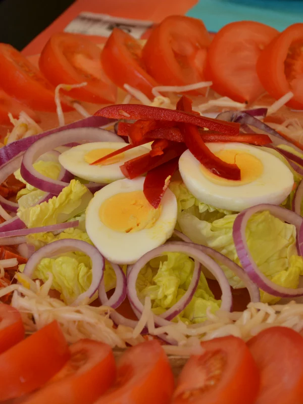 Salade composée d'œufs, tomates, oignons et laitue.